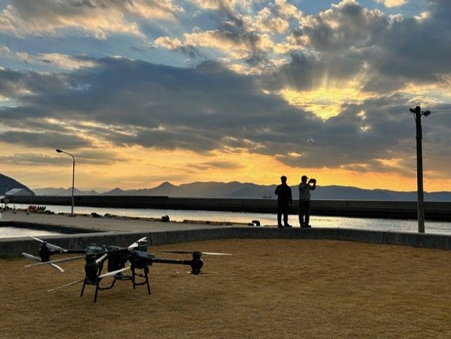 夕景の中でFlyCart30を運用するオペレーター