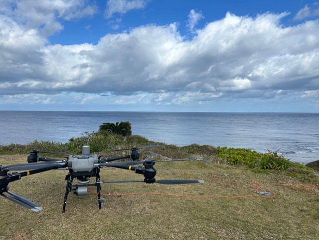 海岸の高台で飛行準備中の産業用ドローン
